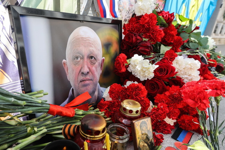 К стихийному мемориалу в память о Пригожине люди несут свечи и цветы