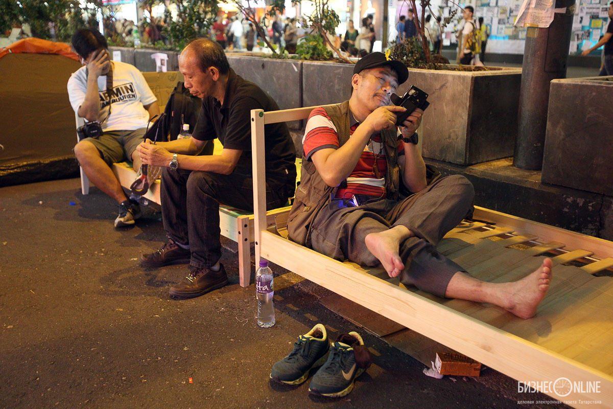 Сторонник «Оккупай Централ» сидит на кровати в районе Монгкок. В этом районе наиболее часто происходят столкновения с группой «Антиоккупай»