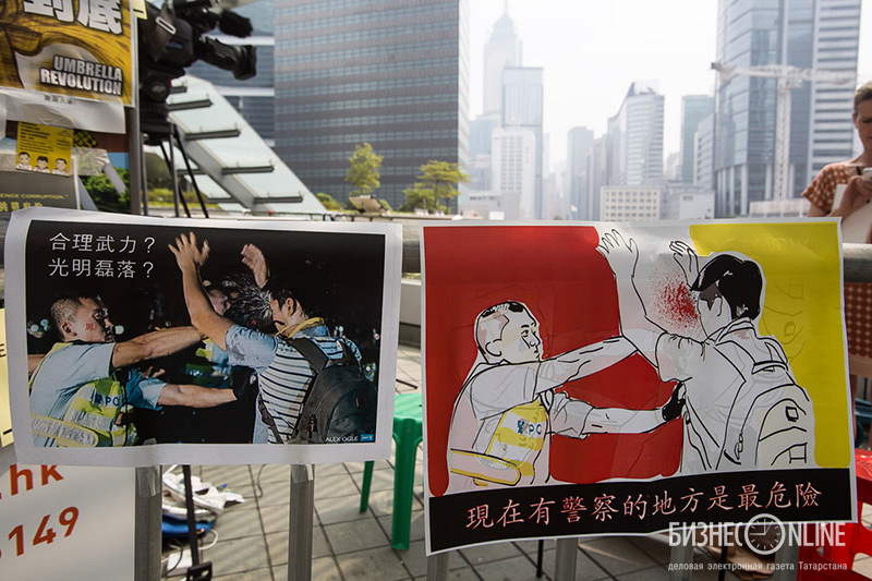 Фотографии агенства AFP, на которой сотрдуник полиции применяет перцовый спрей, развешаны по всему лагерю