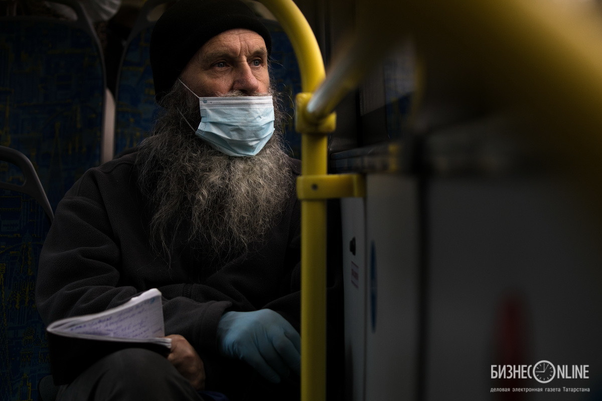 Дума. Пожилой мужчина в защитной маске и перчатках в салоне автобуса в Москве. Фото: Алексей Белкин