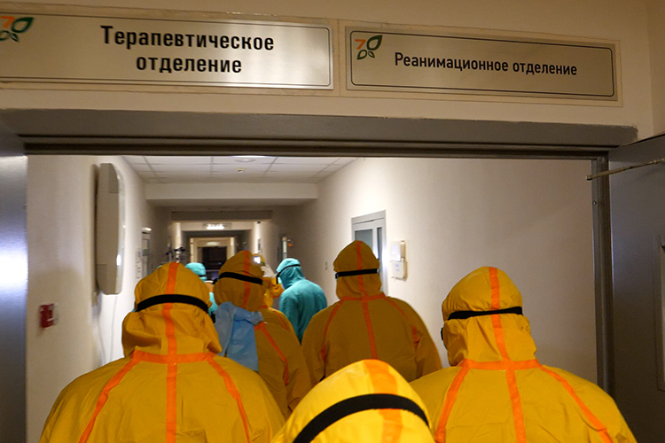 На первом этаже депутатам помогли одеться в желтые противочумные костюмы, а затем проводили на третий этаж больницы