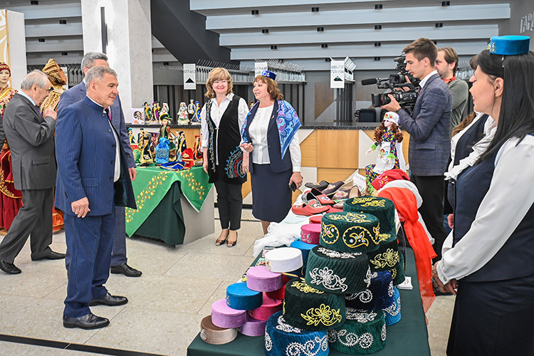 Президент Татарстана остановился возле стенда Арского района, отсюда в столицу привезли разноцветные тюбетейки и женские косынки с вышивками, украшения, одежду и кожаную обувь с элементами этники