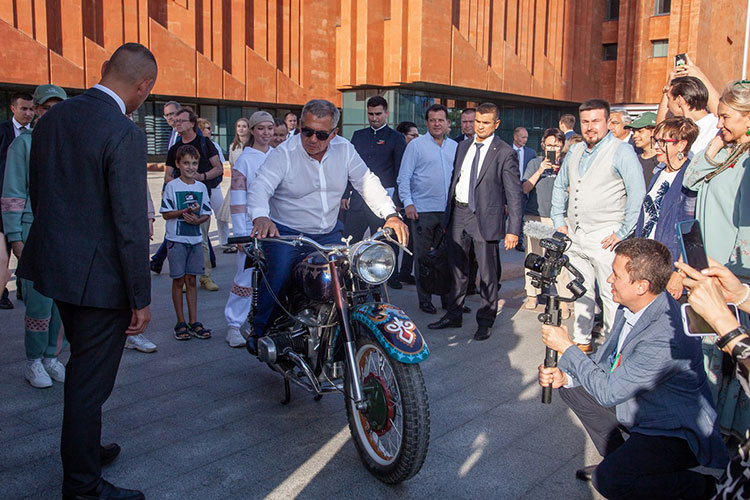 Руководитель республики перекинулся парой фраз с фронтменом группы Gauga Оскаром Юнусовым, сфотографировался за рулем мотоцикла с татарскими орнаментами и прошел в библиотеку, где экскурсию провел Ильяс Гафаров