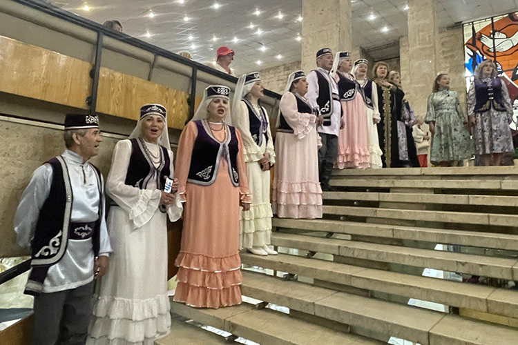 В фойе зрителей встречали девушки в традиционных платьях, поющие на родном языке