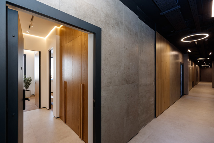 Коридоры на этажах оформлены в стиле лофт. Брутальный серый бетон на стенах сочетается с декоративной плиткой под дерево