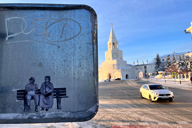 Работа Ивана Симонова из серии «Маленькие люди» в Казани (январь 2024 года). Сверху на дорожном знаке — тег петербургского художника Dusto