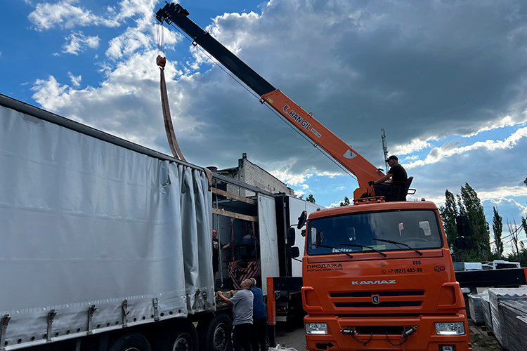 Прямо на фуру с помощью крана затащили небольшой погрузчик. После этого две машины с грузом пристыковались друг к другу прицепами