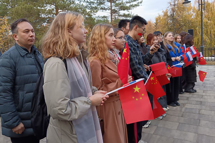 На начало открытия у памятника собрались преподаватели и студенты вуза преимущественно из Китая. Им раздали по два флажка — КНР и России