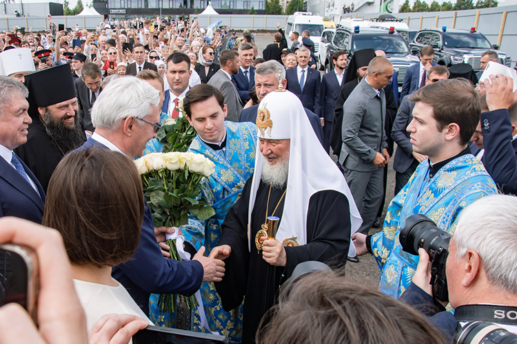 Патриарха Кирилла встретили гендиректор КАМАЗа Сергей Когогин, Наиль Магдеев и епископ Гавриил с тремя большими букетами белых роз