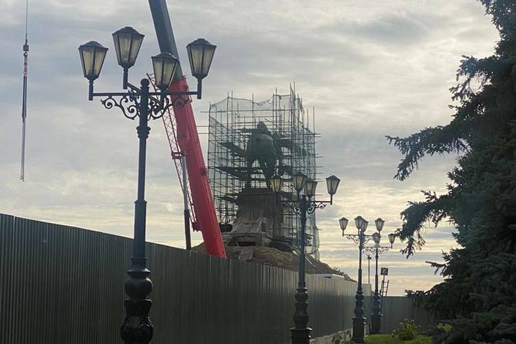 Сама фигура окружена строительными лесами