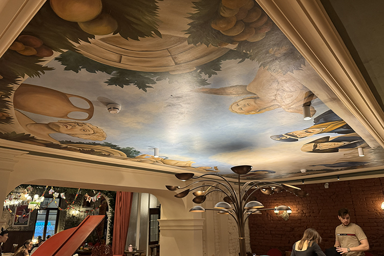 Зал &mdash; двухуровневый, с высокими лепными потолками и фресками, карнизами и деревянной лестницей, укрытой пестрым ковром