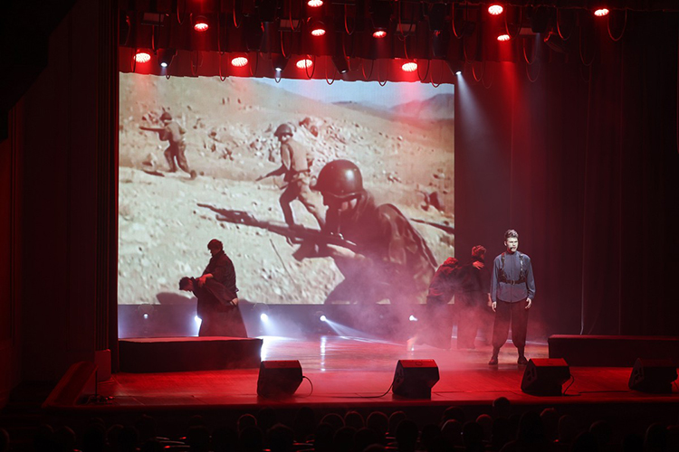  На сцене также звучат вокальные и танцевальные номера, а на заднем фоне &mdash; вновь кадры афганской кинохроники