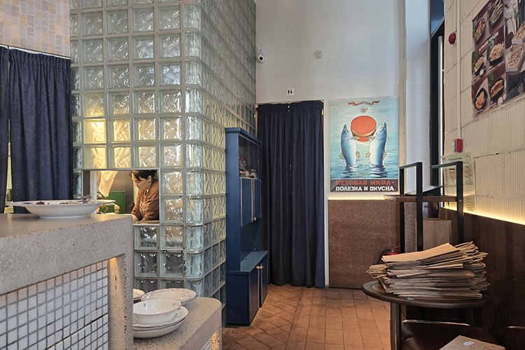 Обычно в ресторанах видна только работа, здесь же &mdash; бутылки с соусами, контейнер с зеленью, стеллаж с тарелками, варежки для горячих посудин и даже носки с уточками у повара