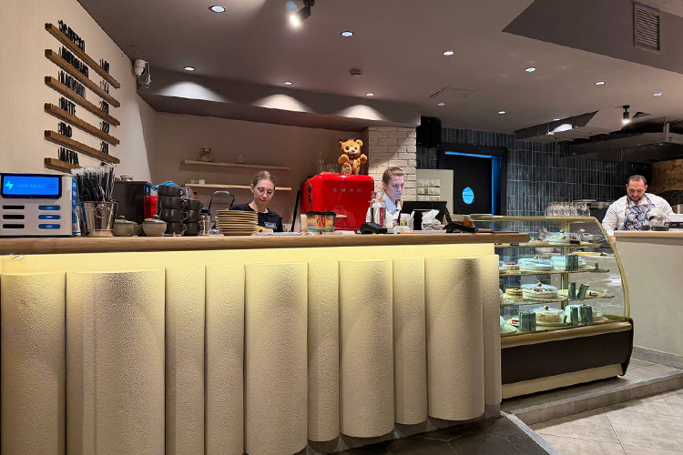 Фасад барной стойки обшит рельефными белыми панелями