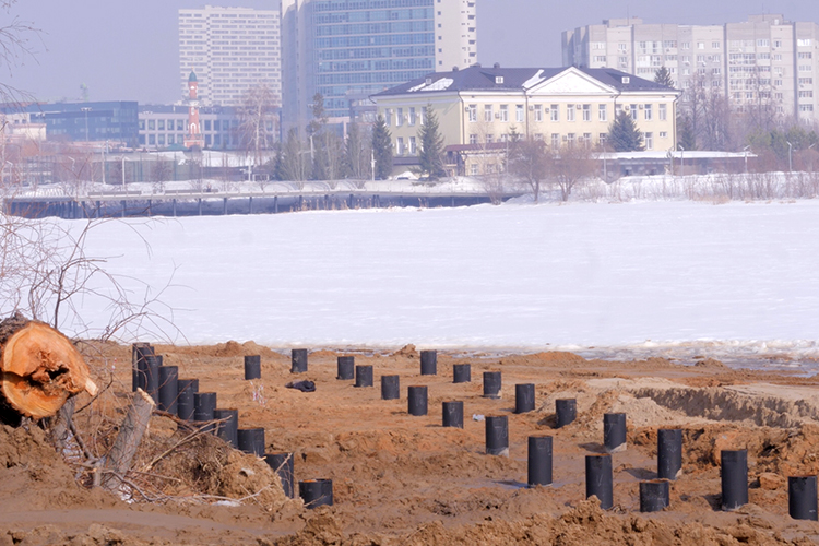 На месте уже вовсю пилят деревья &mdash; американские клены. Чуть поодаль погрузчик насыпал на воду песок, привезенный самосвалом. Тут же забивают сваи, на которые потом установят хорошо знакомые горожанам и гостям столицы Татарстана «парящие» пешеходные дорожки, как на первой и второй очередях набережной