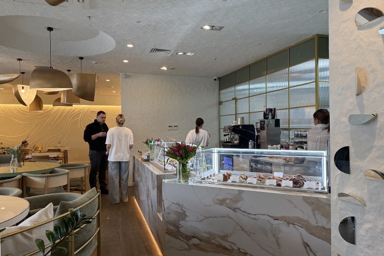 Интерьер сдержанный, в природных оттенках: белый, шалфейно-зеленый и медно-золотой. Под белым фактурным потолком висят крупные светильники в виде зерен гречки &mdash; символа места &mdash; все того же золотистого цвета