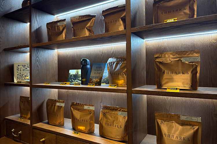 Сразу притягивает взгляд высокий стеллаж в темном дереве с подсветкой и золотыми ручками