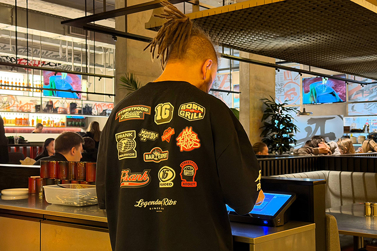 Дресс-код персонала &mdash; черный оверсайз: на ком-то футболка-мерч стороннего табачного бренда, на ком-то фирменный вариант с яркими тематическими нашивками на спине