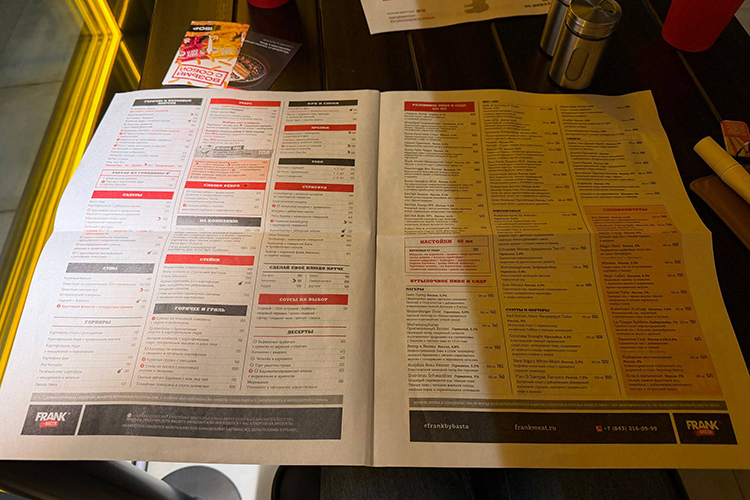 Меню выглядит как арт-объект &mdash; полноценная газета с намеренно перегруженной версткой: блюда, акции, адреса, ссылки, английская версия