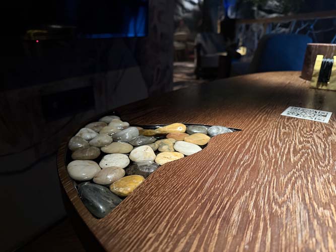 Столы сделаны прикольно: на маленьких изображены наскальные рисунки, на больших &mdash; вставки с настоящими камнями, которые залили слоем эпоксидной смолы