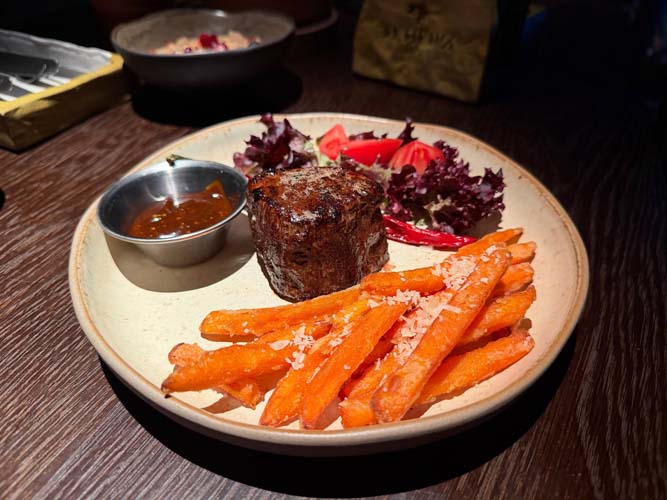 Стейк из говядины &mdash; добросовестный medium rare. Само мясо вкусное, но пресное, поскольку к нему подают очень яркий соус и батат