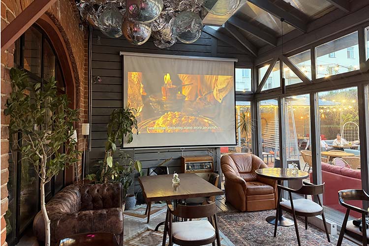 Переходное пространство между основным залом и террасой. На стене &mdash; большой проекционный экран, над головой &mdash; несколько крупных надувных шаров серебристого цвета