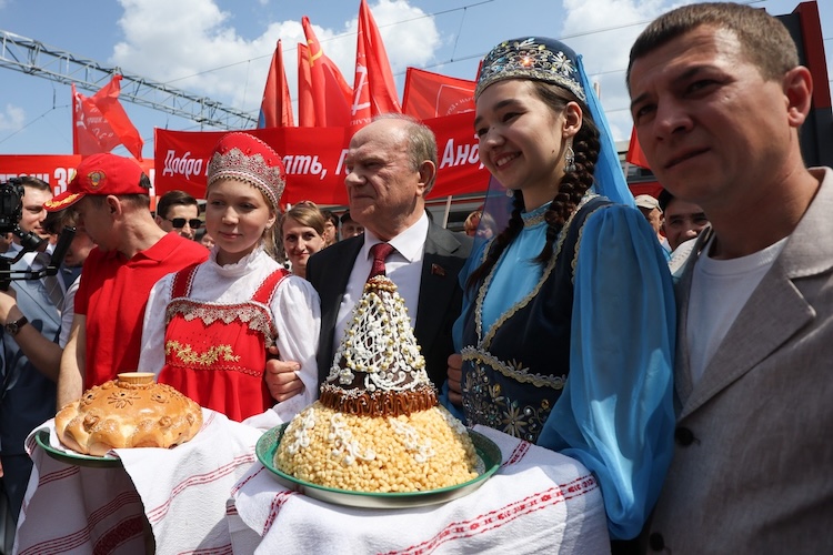 Встречали «красного» лидера по традиции две девушки: хлебом-солью, одетая в русский, и чак-чаком, облаченная в татарский национальный костюм